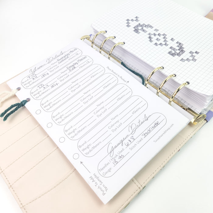 Yarn Details page shown with handwritten entries and graph paper with a hand-drawn knitting chart visible on the opposite page through gold ring binding