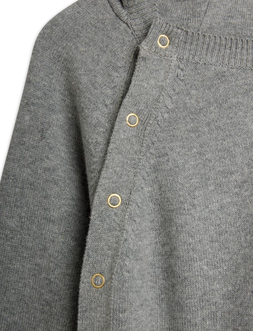Close-up of a gray knit romper showing the ribbed mock neck collar and a vertical row of gold-tone buttons.