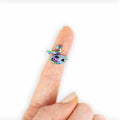 Rainbow iridescent peacock-shaped yarn tensioning ring worn on index finger