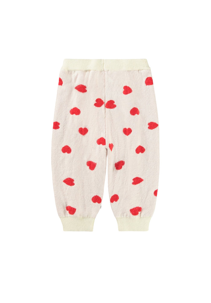 Cream-colored pants with red heart patterns on a white background