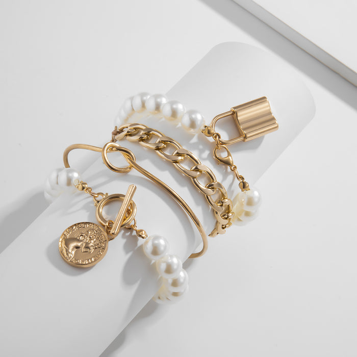 Set of four gold-tone bracelets featuring a pearl strand with a padlock charm, a thick curb chain, a gold bangle, and a coin pendant toggle bracelet.