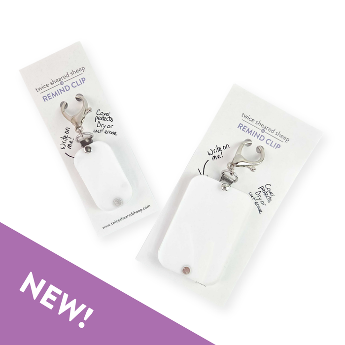 Two Remind Clips in branded retail packaging showing the reusable note tag with lobster clasp and protective cover