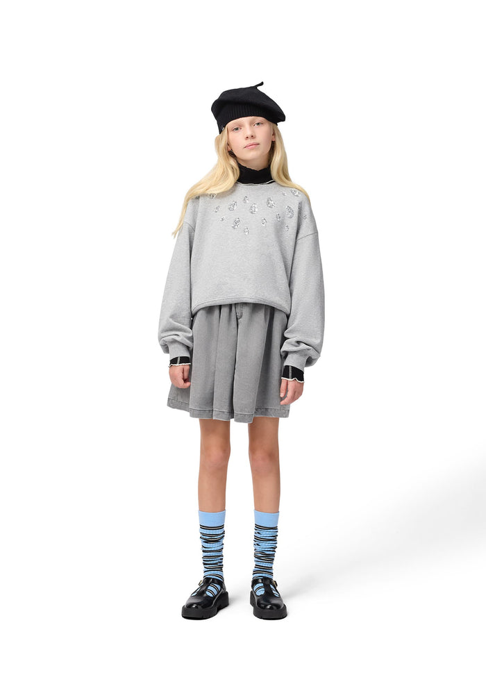 Person wearing a gray outfit with a black beret on a white background