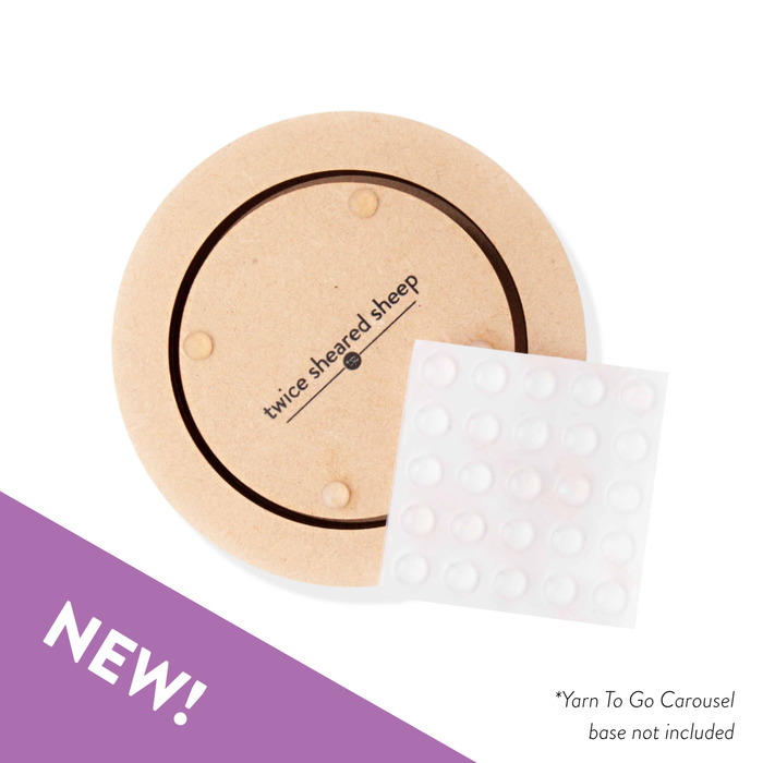 Round wooden product with white mesh bag and 'twice sheared sheep' branding, on a white background with purple accent.