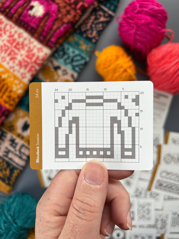 Hand holding a Rhinebeck Doodle sweater colorwork chart card