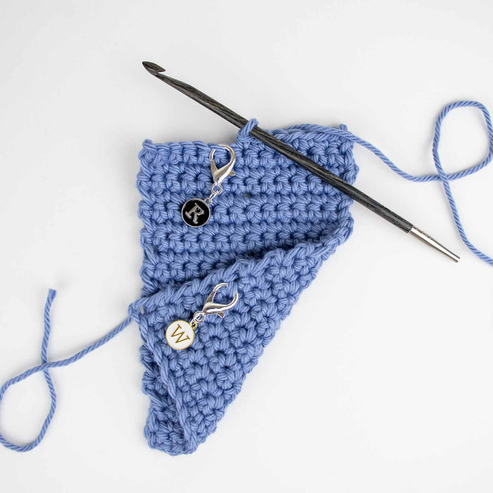 Right Side and Wrong Side clip markers attached to blue knitting swatch showing markers in use