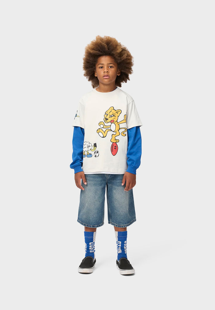 Child wearing a colorful graphic t-shirt and denim shorts on a white background