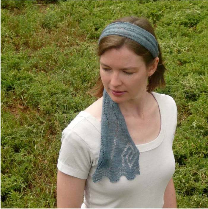 Woman wearing gray-blue Rill lace scarf as headband with end draped over shoulder showing leaf lace detail
