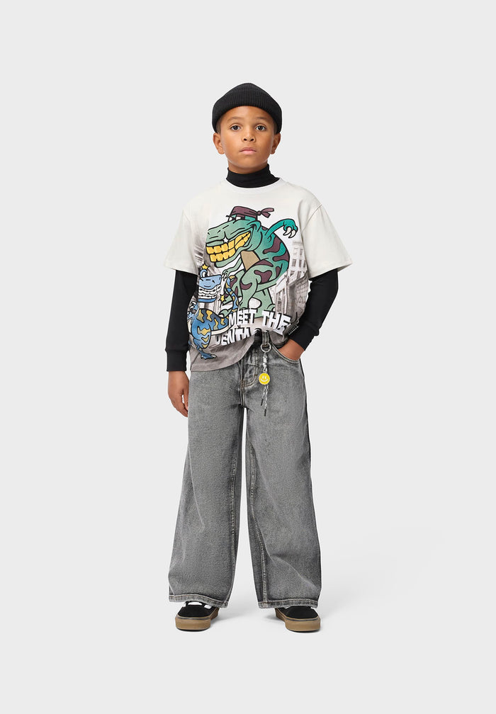 Child wearing a graphic t-shirt and jeans on a white background