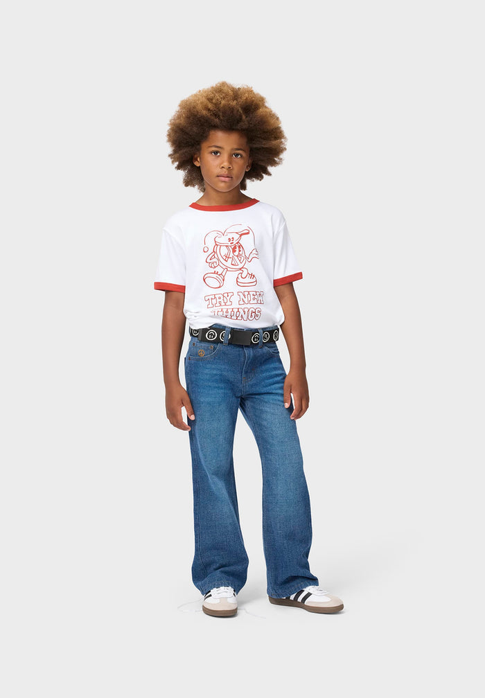 Person wearing a white t-shirt with red trim and blue jeans on a white background