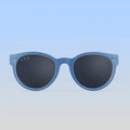 Blue sunglasses with dark lenses on a light blue background