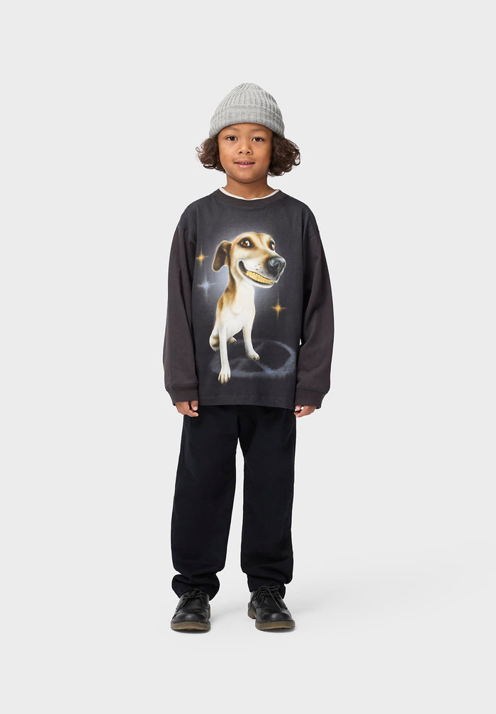 Child wearing a dark LS tee  with a dog graphic on a white background
