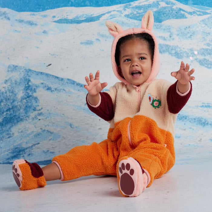 Child wearing sherpa outfit with a snowy background