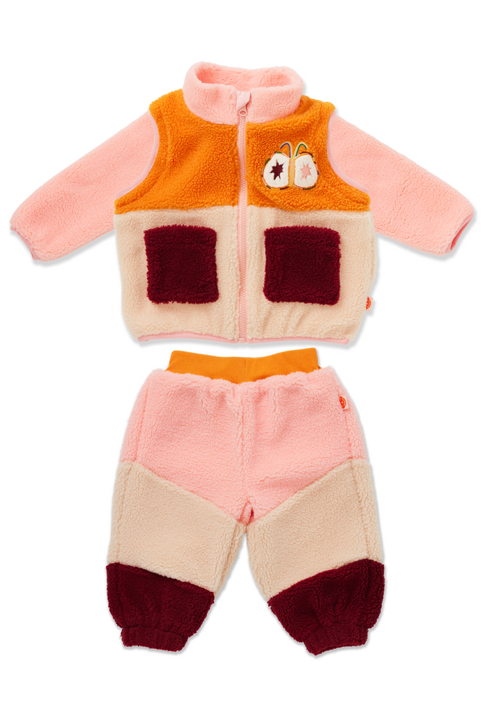A two-piece baby fleece outfit set consisting of a zip-up vest and matching pants. The vest features a soft pink long-sleeve base, a bright orange upper panel, cream-colored front pockets, and a small embroidered bunny patch on the chest.