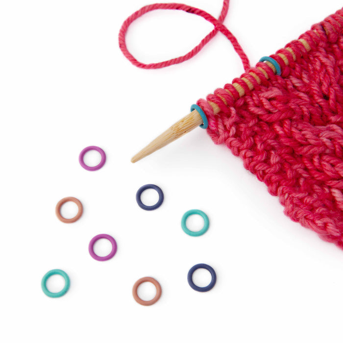 Simple Ring stitch markers in rainbow medium size on knitting needles showing scale and fit