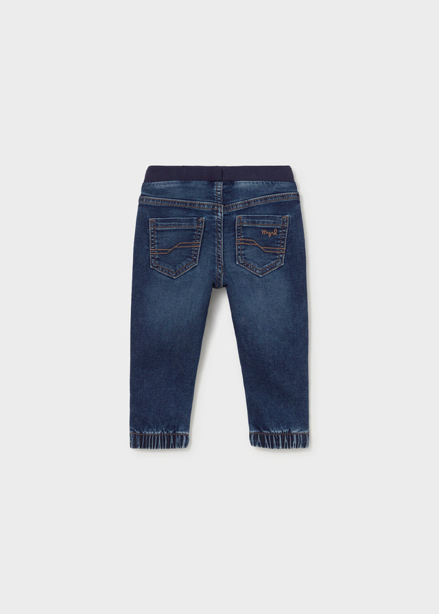 Back view of a pair of blue jeans on a white background
