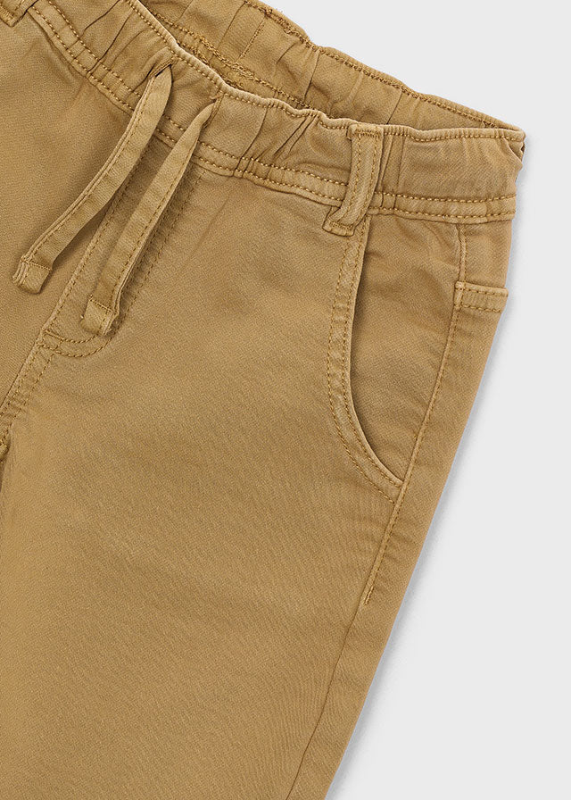 Close-up of brown pants with a white background