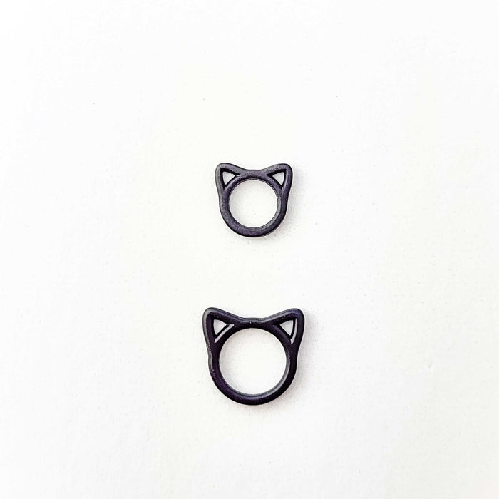 Two black cat stitch markers in small and large sizes shown side by side to compare the two available sizes