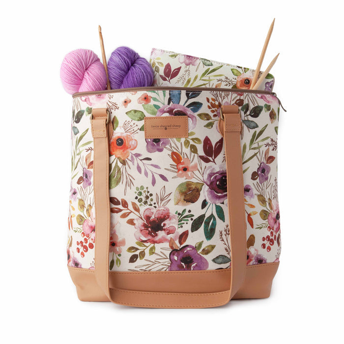 Close-up of Spring Floral Mega Trinity Bag fabric showing the watercolor wildflower and botanical print detail with tan leather trim