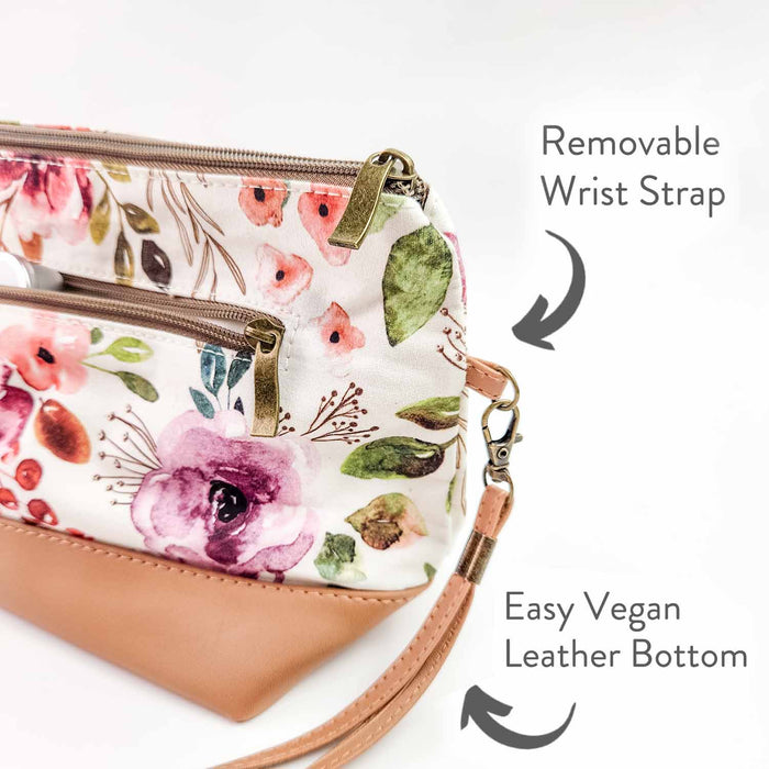 Side view of Spring Floral Trinity Bag showing the removable wrist strap clip and easy-clean vegan leather bottom with labeled callouts