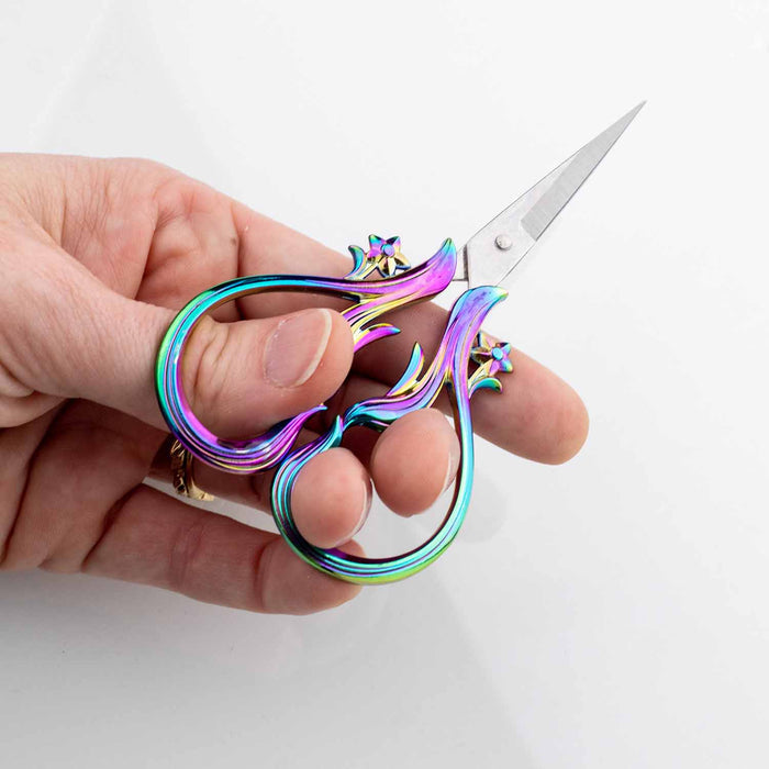 Hand holding the Star Dust Rainbow embroidery scissors from a different angle showing the comfortable grip and sharp pointed blades