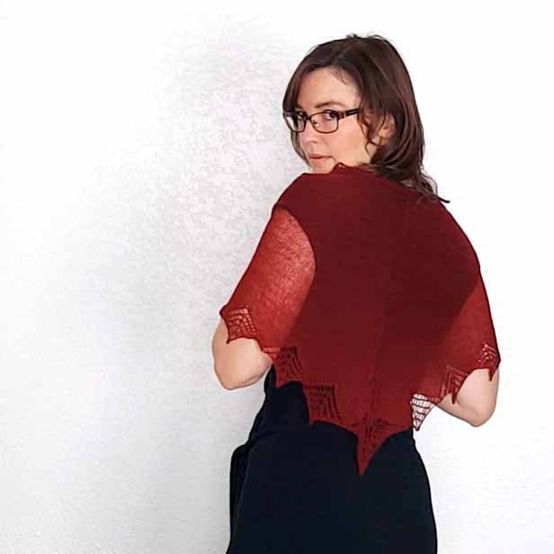 Woman wearing deep red Stardust lace shawl with pointed star border shown from behind