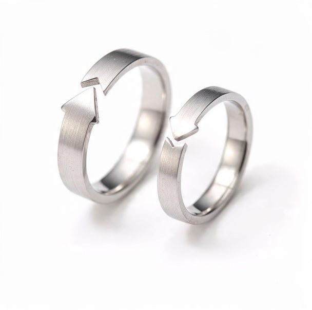 A set of two brushed sterling silver adjustable rings featuring arrow cutout designs, one in a larger size and one smaller, displayed side by side on a pure white background.