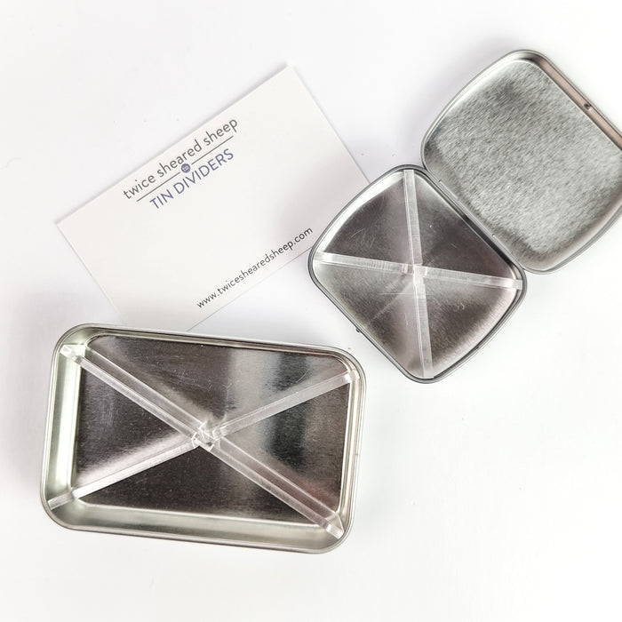 Clear cross-shaped Storage Tin Divider shown inside an open silver tin demonstrating how it creates organized compartments