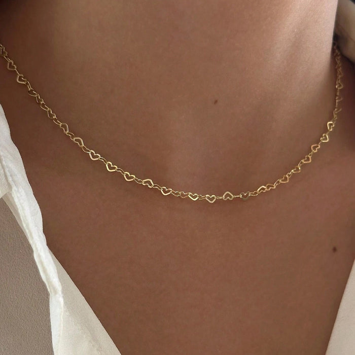 Gold minimalist heart-shaped link necklace for women worn on neck, Korean style dainty jewelry fashion.