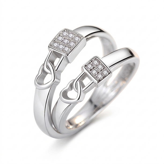 "Pair of silver heart-lock rings featuring a square centerpiece encrusted with shimmering crystals on a white background."