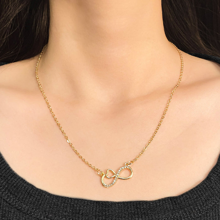 Gold infinity heart necklace for women with crystal accents, eternal love symbol pendant on a thin gold chain.