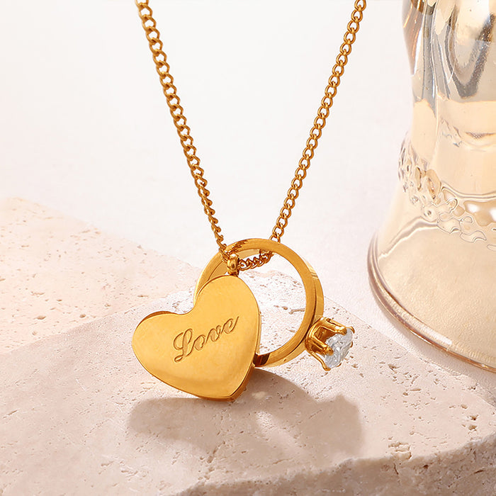 Gold necklace with an engraved "Love" heart pendant and a small crystal solitaire ring charm, romantic boutique jewelry for women.