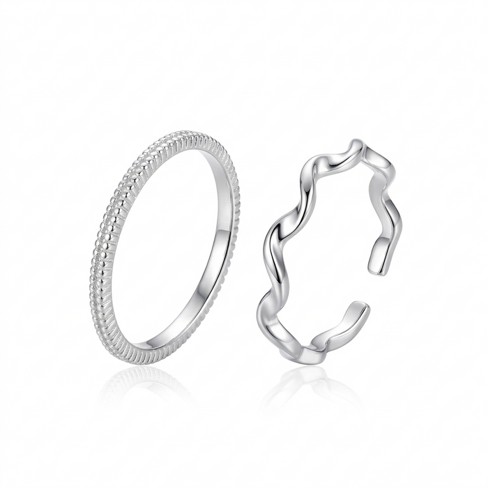 "Minimalist silver ring set featuring one textured beaded band and one adjustable wavy ripple band on a white background."