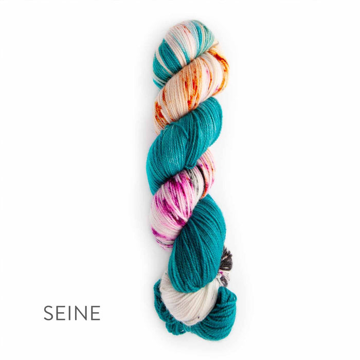 Single skein of TSS Classic Sock Paints yarn in Seine colorway featuring bold teal sections with splashes of cream, orange, and pink on a white background