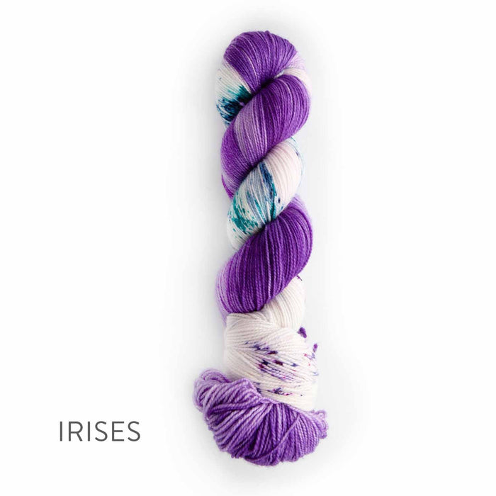Single skein of TSS Classic Sock Paints yarn in Irises colorway featuring rich purple sections with white and teal accent splashes on a white background