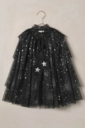 Black tulle cape with star patterns on a beige background