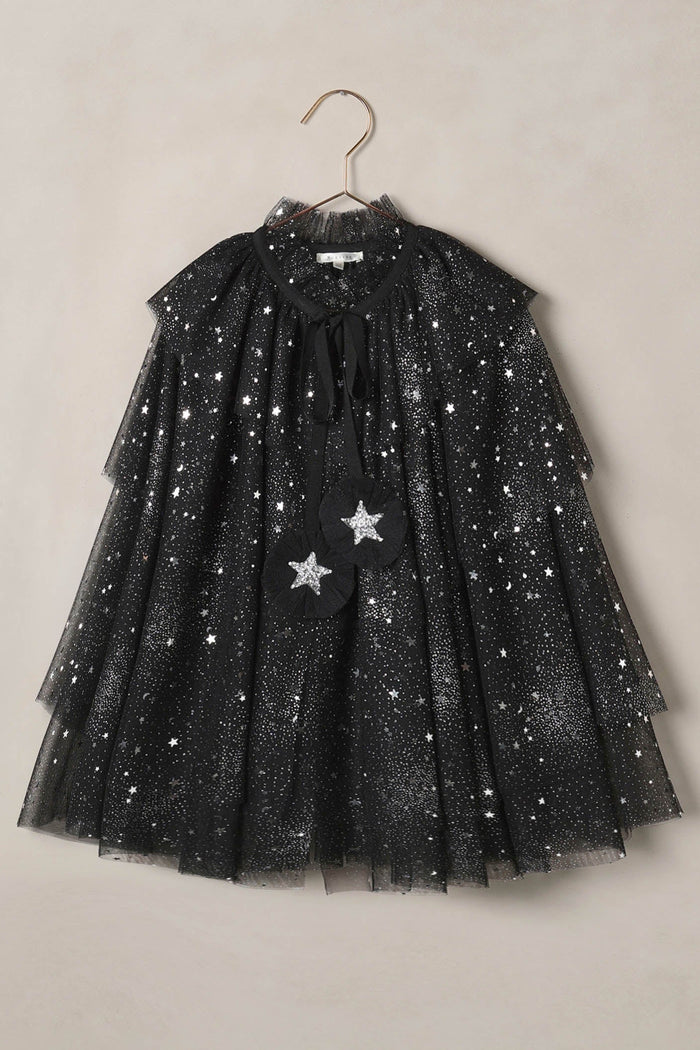 Black tulle cape with star patterns on a beige background