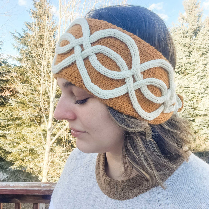 Model wearing the Twining Roads Headband in golden mustard with white intertwining cord quill cables, side profile view outdoors