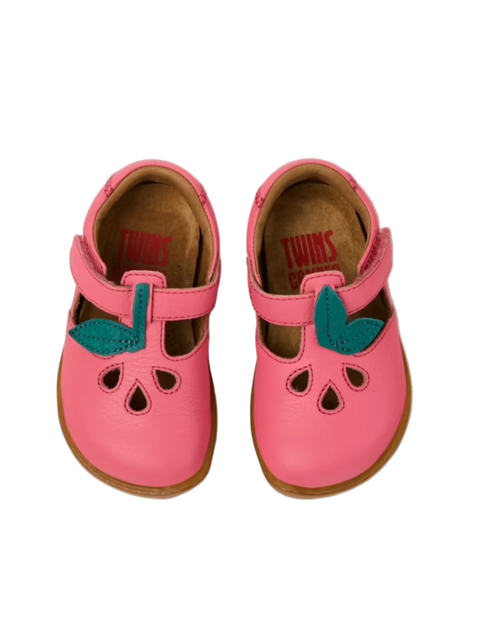 Pair of pink children's shoes with green accents on a white background