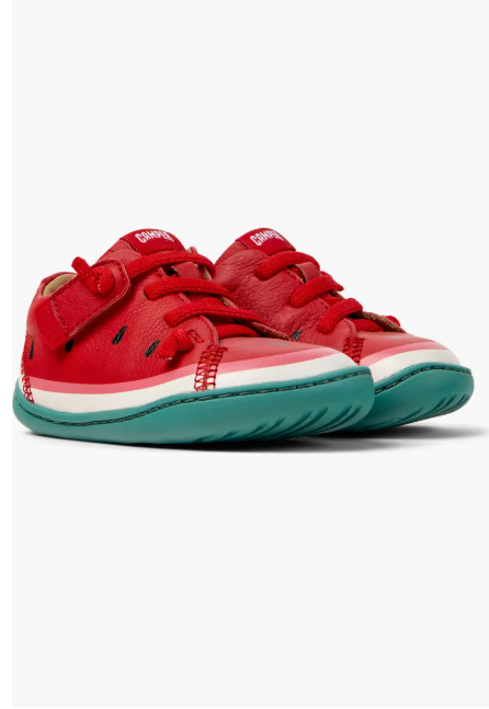 Red children's shoes with green soles on a white background