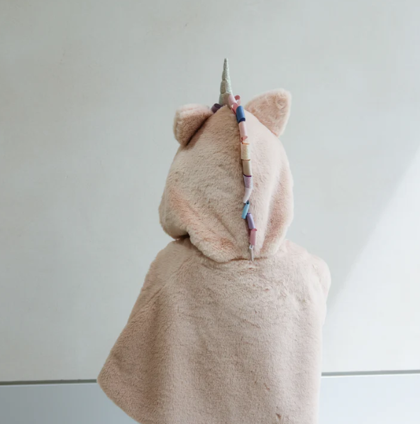 Unicorn-shaped cape with a colorful horn on a white background
