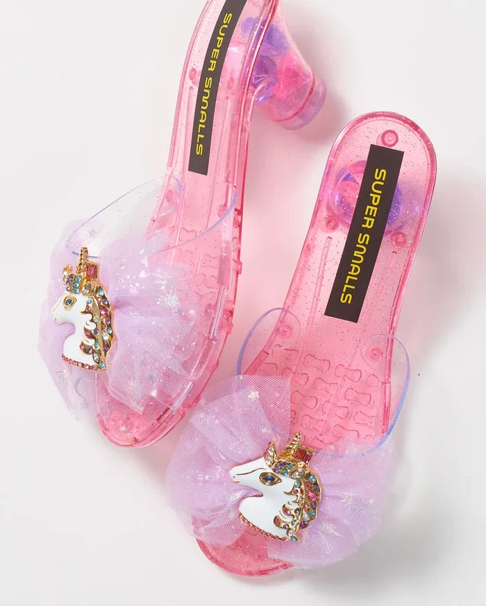 Clear plastic shoes with unicorn charms and 'Super Snails' branding on a light background