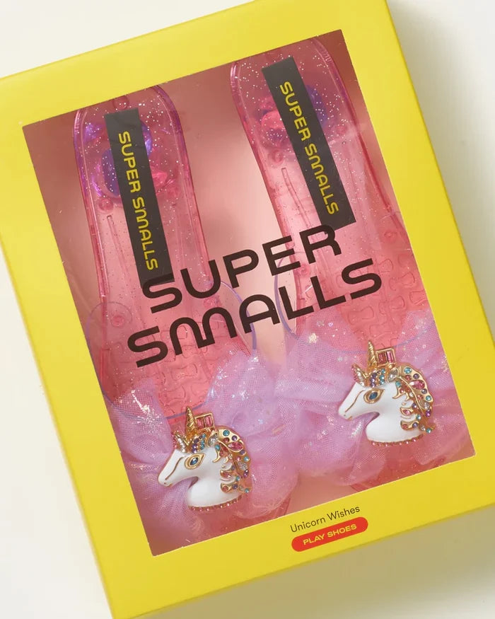 Product packaging with 'Super Smalls' branding and unicorn-adorned shoes.