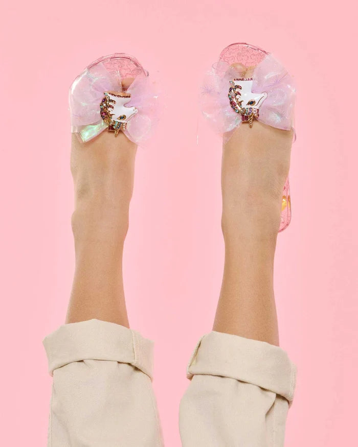 Transparent sandals with floral decorations on a pink background