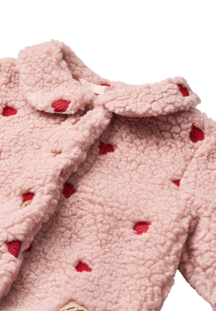 Close-up of a pink fleece jacket with red heart patterns on a white background