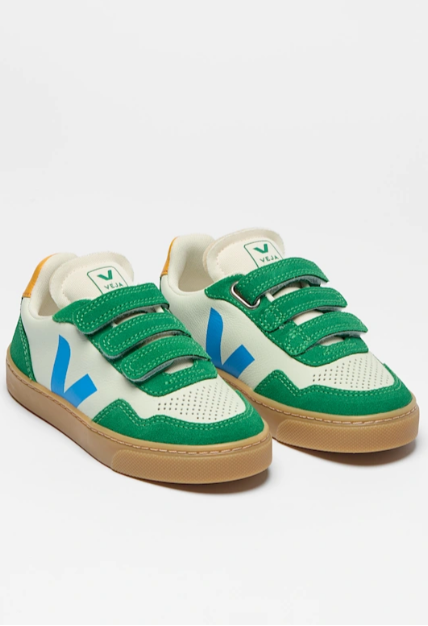 Green and white sneakers with brown soles on a light gray background
