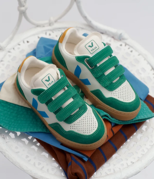 Green and white sneakers with brown soles on a white surface