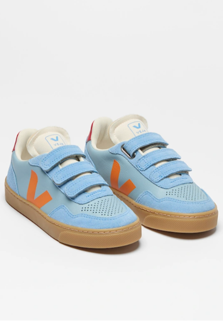 Pair of blue children's sneakers with orange accents on a white background