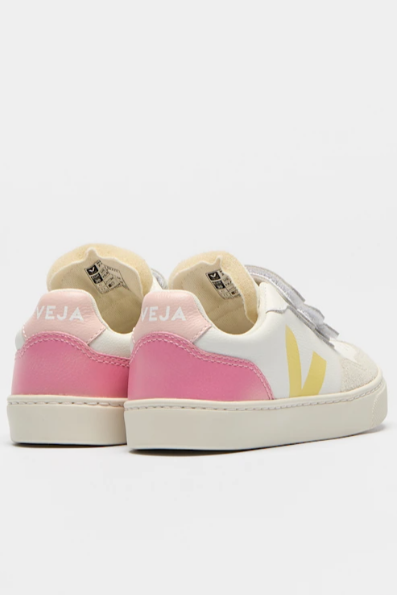Pair of pink and white sneakers with a yellow accent on a light gray background