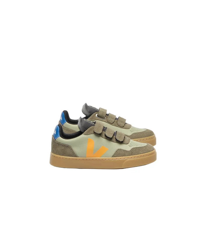 Sage green sneaker with orange logo and blue detail on a white background